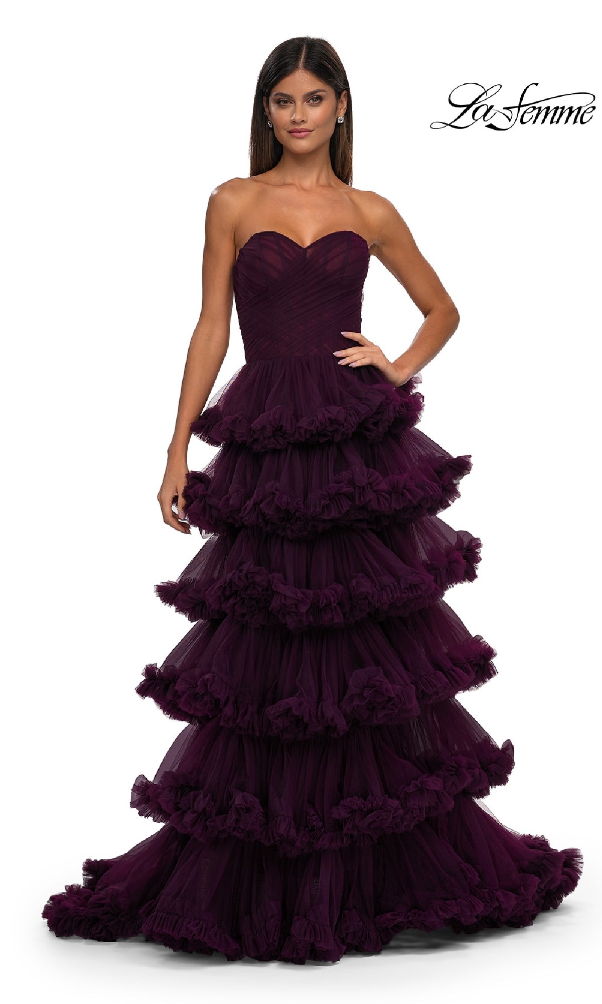 A woman models the Strapless Ruffled Prom Ball Gown: La Femme 32721—a dark purple, tiered strapless gown with a fitted bodice—while standing against a white background. The La Femme logo is shown in the top right corner.